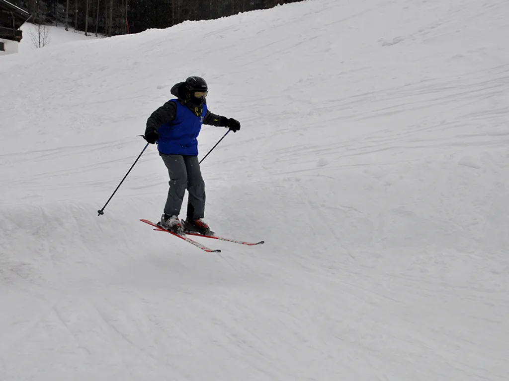 Skifahrerin fährt einen weiten Hang hinunter.